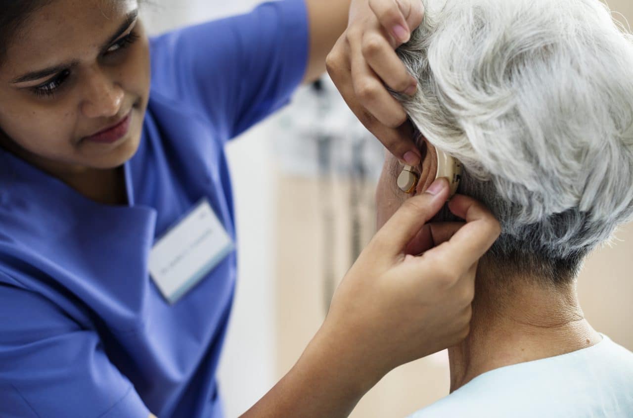Woman having her hearing aids adjusted by a specialist.