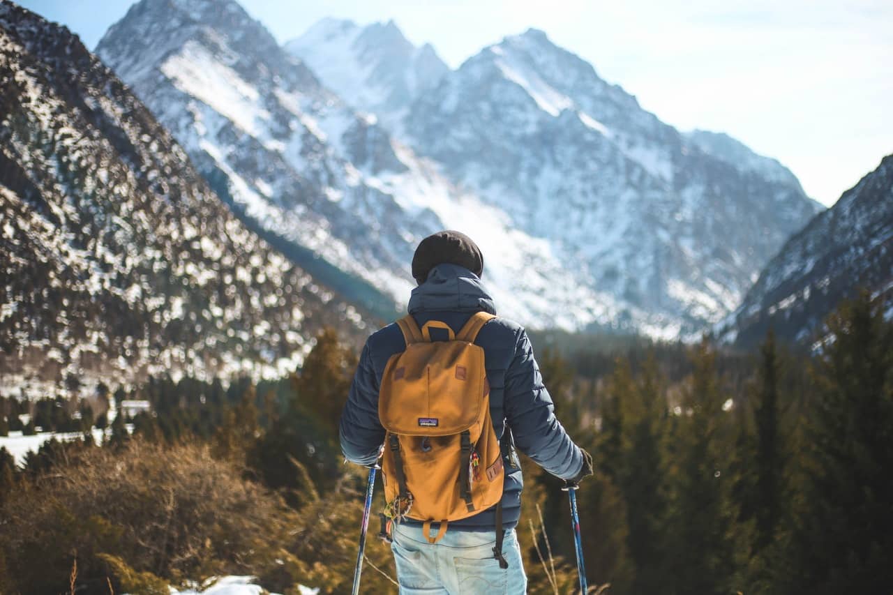 man hiking in the mountains with hearing aid