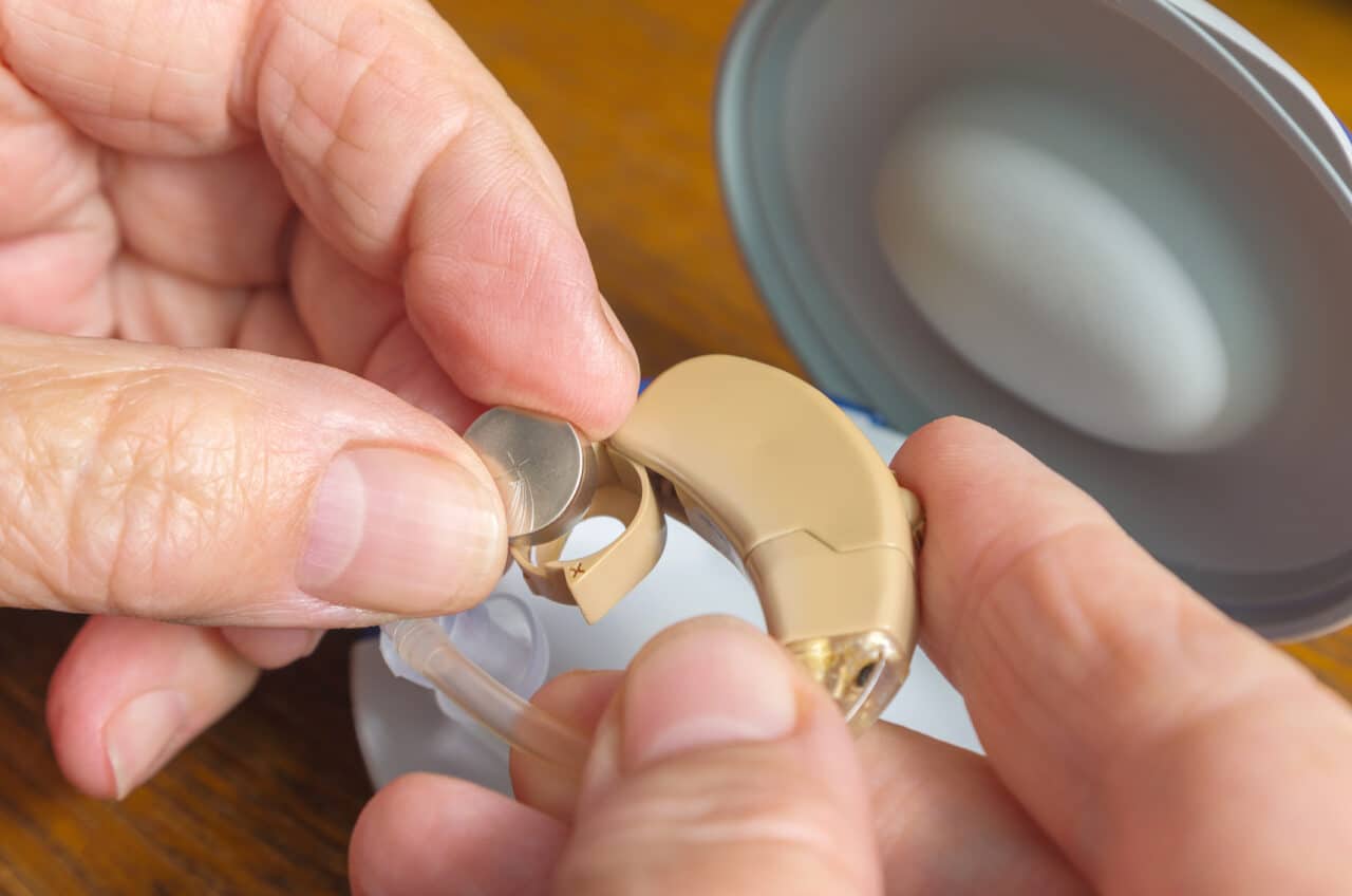 Close-up of woman changing her hearing aid battery.
