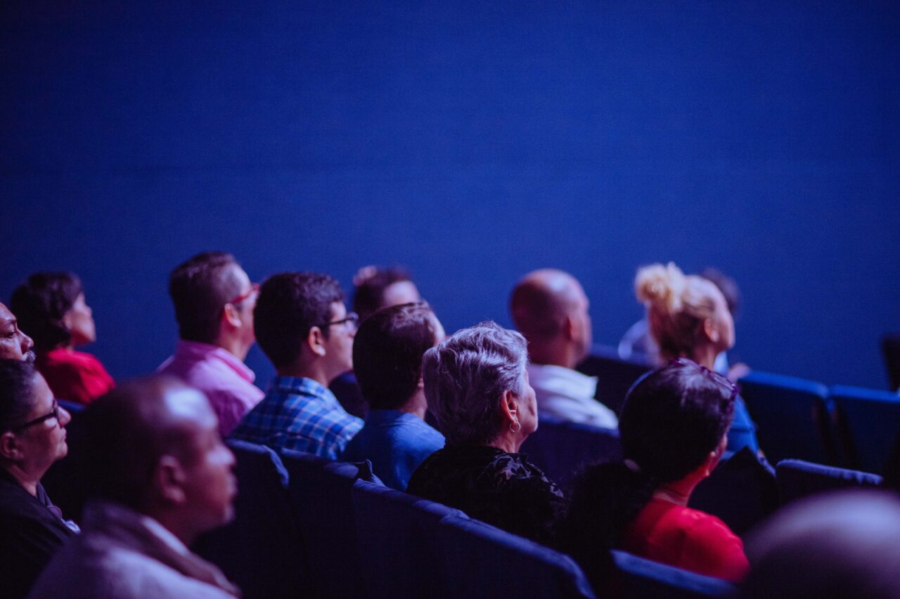 Group of people in the audience at a public event in an auditorium.